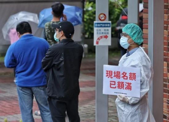 资料图：台湾快筛站现场名额额满，医护人员于排队末端举牌提醒。图片来源：台湾《联合报》，记者 曾原信 摄