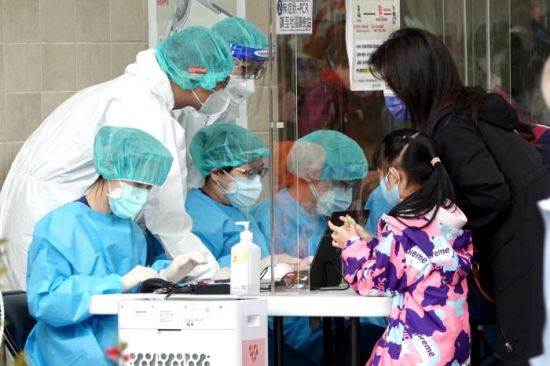 台湾本地疫情尚未趋缓，许多家长带小孩筛检。图片来源：台湾中时新闻网 黄世麒 摄