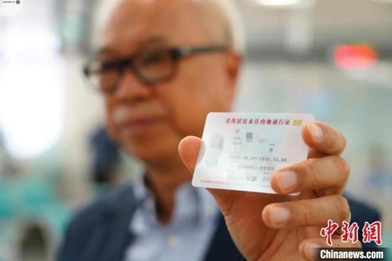 2020年10月15日，香港居民刘先生领到编号001回乡证，成为首位在内地直接换补发回乡证的港澳居民 蒋琦超 摄