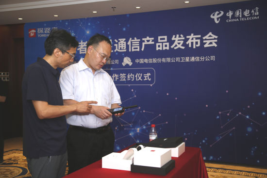 探路者集团总裁何华杰(左)和中国电信卫星公司总经理杨岭才试用新产品 主办方供图