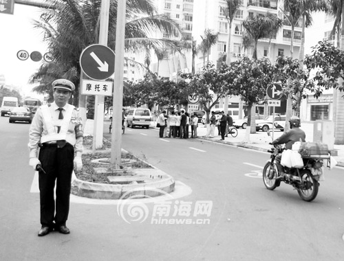 交警在人民路一摩托车分道行驶标志前为司机指