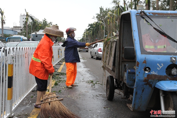 7月19日上午11时，海口环卫人员正在清理道路上的树木，为了尽快恢复道路畅通他们从早上7点开始工作 邓奥赛 摄