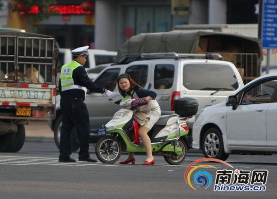 　龙昆南，一女子骑电动车闯红灯被抓。